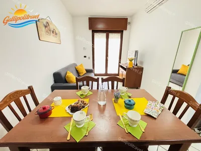 Soggiorno tavolo divano grigio, trilocale B2/4 al Residence Rosa Virginia, Gallipoli