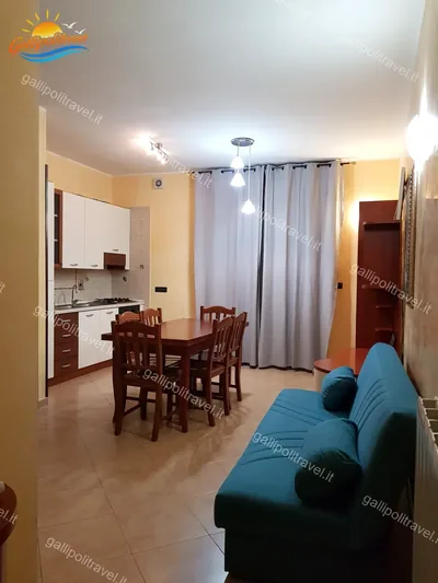 Soggiorno divano turchese tavolo legno, trilocale D1/3 al Residence Rosa Virginia, Gallipoli