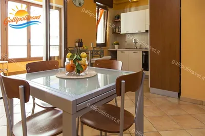 Zona pranzo tavolo vetro agrumi, trilocale F1/1 al Residence Rosa Virginia, Gallipoli